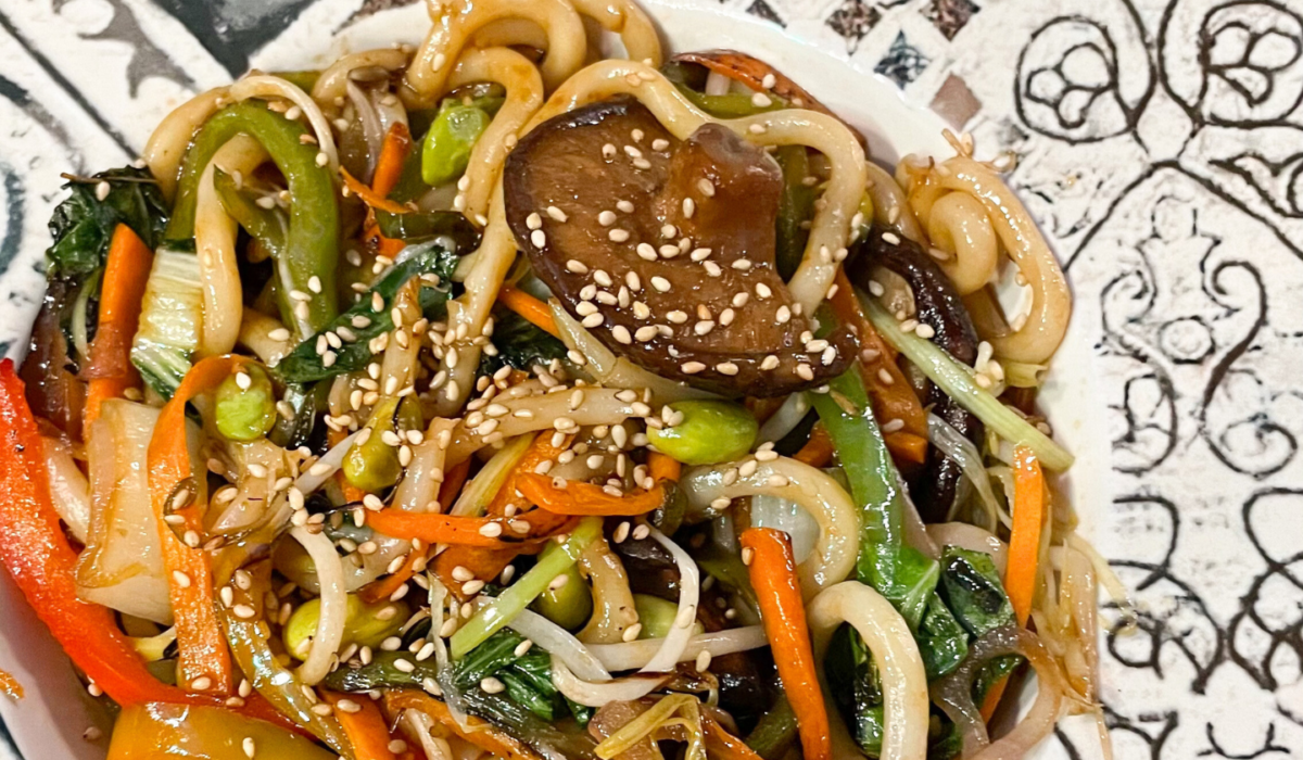 Udon saltati con verdure miste, germogli di soia, edamame e semi di sesamo