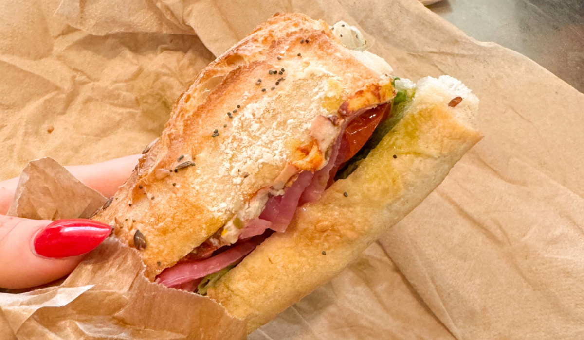 Panino con cipolla caramellata, pomodorini confit, pesto e formaggio veg affumicato